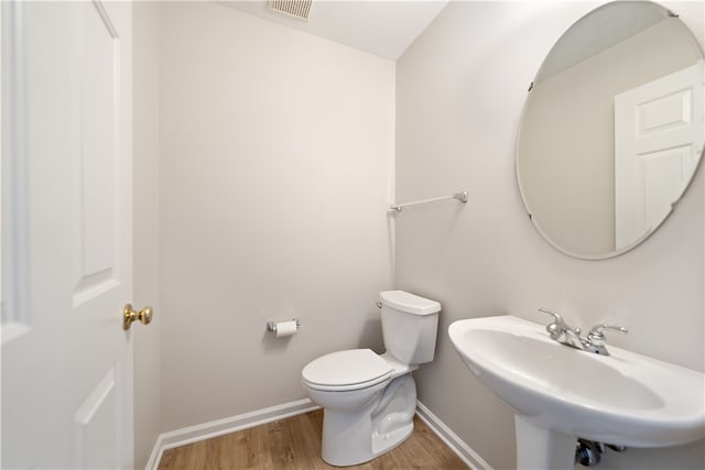 bathroom with hardwood / wood-style floors, toilet, and sink