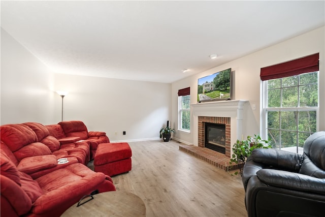 living room featuring light hardwood / wood-style floors and a brick fireplace