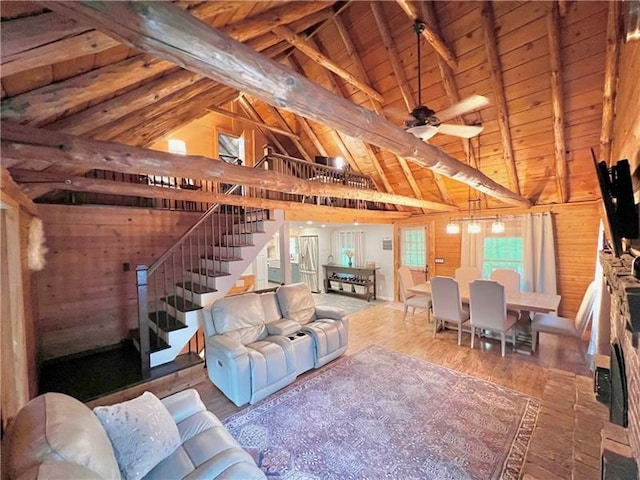 living room with wooden ceiling, hardwood / wood-style flooring, ceiling fan, wooden walls, and vaulted ceiling with beams