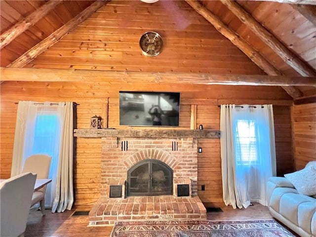 living room with a fireplace, wooden walls, wood-type flooring, vaulted ceiling with beams, and wooden ceiling