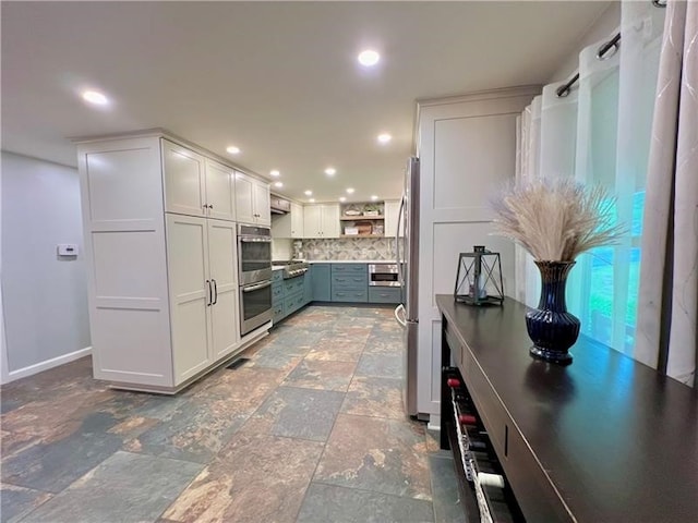 kitchen with white cabinets, stainless steel appliances, and tasteful backsplash