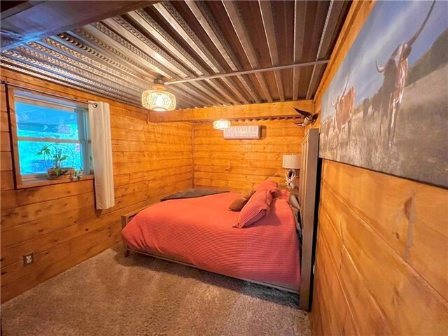 carpeted bedroom featuring wood walls