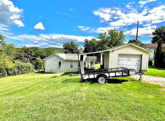 view of front facade with an outbuilding, a garage, and a front yard