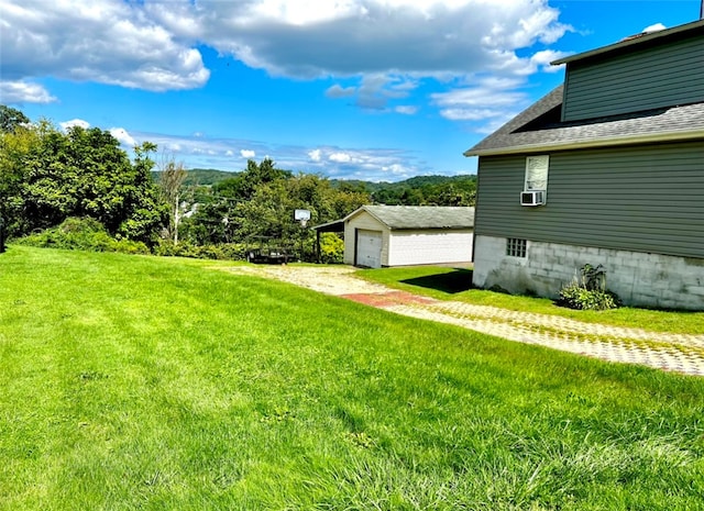 view of yard with cooling unit, a garage, and an outdoor structure