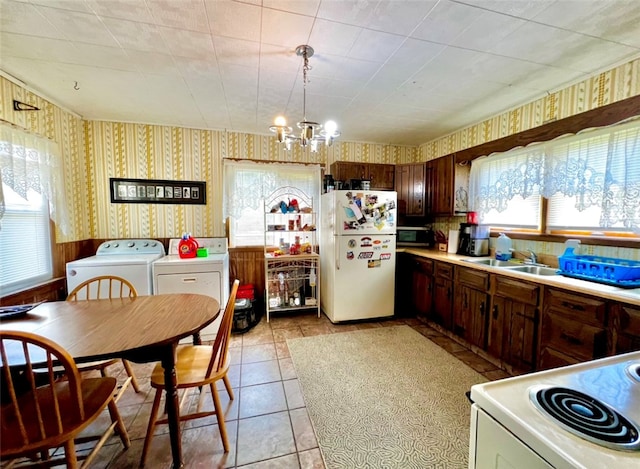 kitchen featuring an inviting chandelier, white appliances, dark brown cabinets, sink, and light tile patterned flooring