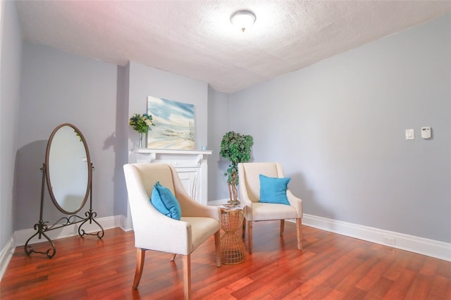 sitting room featuring a textured ceiling and wood-type flooring