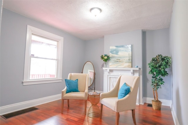 sitting room featuring hardwood / wood-style floors and a textured ceiling