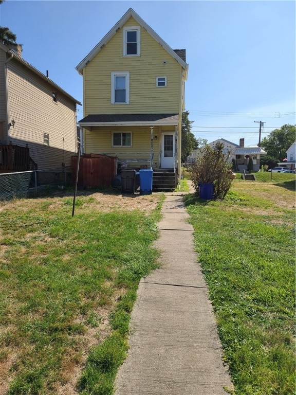 rear view of property with a lawn