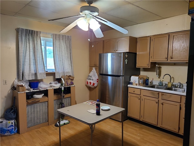 kitchen featuring stainless steel fridge, light hardwood / wood-style flooring, sink, and ceiling fan