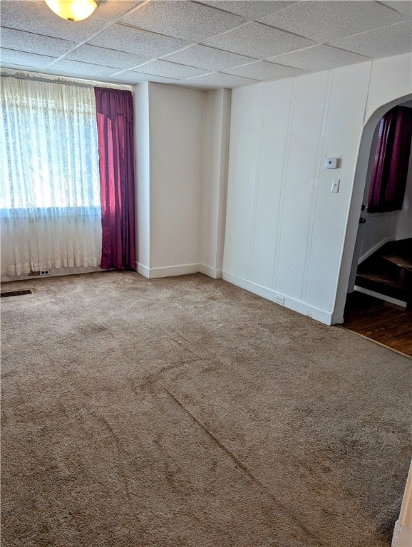 carpeted spare room with a drop ceiling