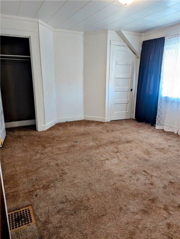 unfurnished bedroom featuring carpet and ornamental molding