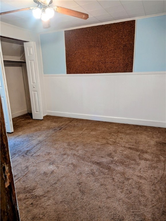 unfurnished bedroom with a closet, ceiling fan, ornamental molding, and carpet floors