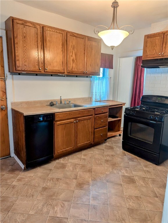 kitchen featuring black appliances, tasteful backsplash, sink, and hanging light fixtures