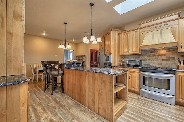 kitchen featuring a kitchen island, stainless steel appliances, light hardwood / wood-style flooring, and a skylight