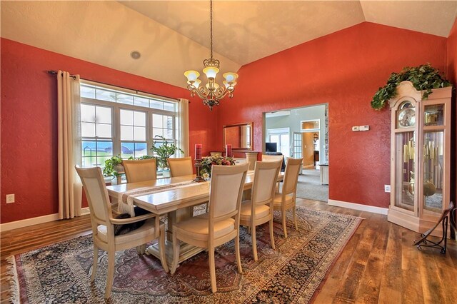 dining area with high vaulted ceiling, dark hardwood / wood-style floors, and a notable chandelier