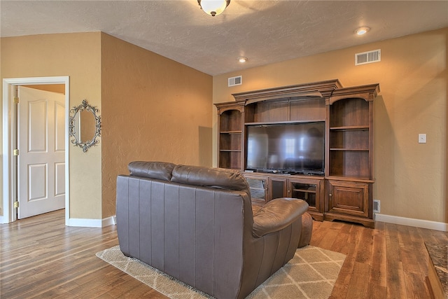 living room with a textured ceiling and hardwood / wood-style floors