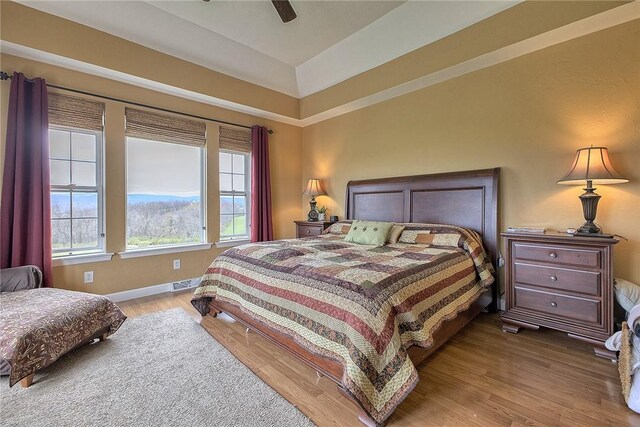 bedroom featuring lofted ceiling, wood-type flooring, and ceiling fan