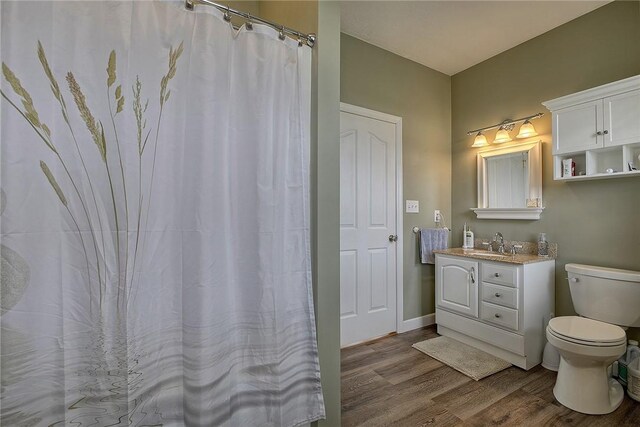 bathroom with toilet, hardwood / wood-style flooring, and vanity