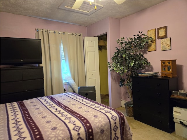 carpeted bedroom with ceiling fan and a textured ceiling