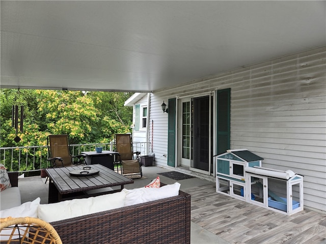 wooden terrace with an outdoor living space with a fire pit