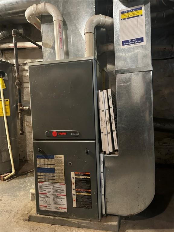 utility room featuring heating unit and gas water heater