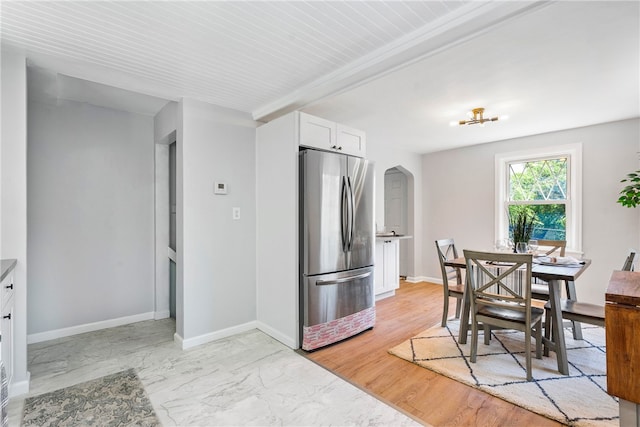 kitchen featuring light hardwood / wood-style flooring, stainless steel fridge, and white cabinets