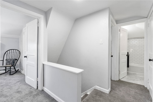 hall featuring light carpet and vaulted ceiling