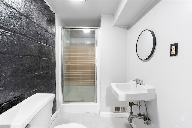 bathroom with crown molding, toilet, a shower with shower door, and tile patterned flooring