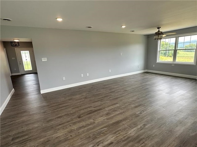 empty room with dark hardwood / wood-style flooring and ceiling fan