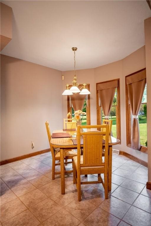 dining space featuring baseboards and an inviting chandelier