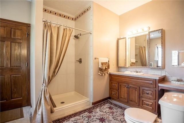 bathroom with vanity, a shower stall, toilet, and tile patterned flooring