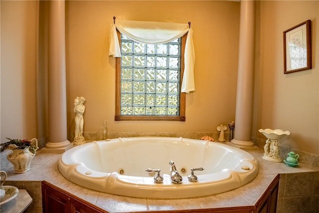 bathroom with a jetted tub and ornate columns