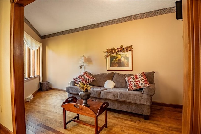 living area featuring baseboards, visible vents, and wood-type flooring