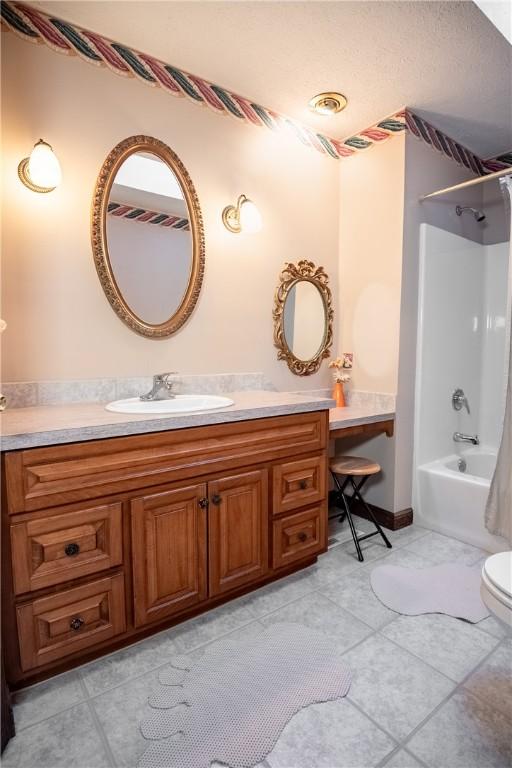 full bath featuring toilet, bathtub / shower combination, vanity, and tile patterned flooring