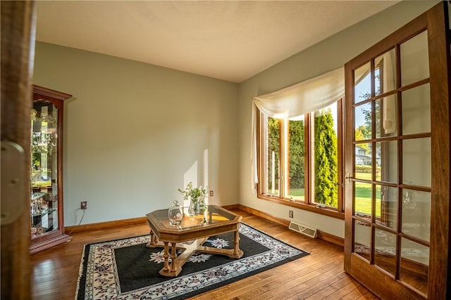 sitting room featuring baseboards, visible vents, and wood-type flooring