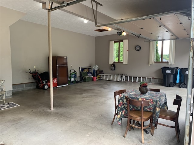 garage with a garage door opener and freestanding refrigerator