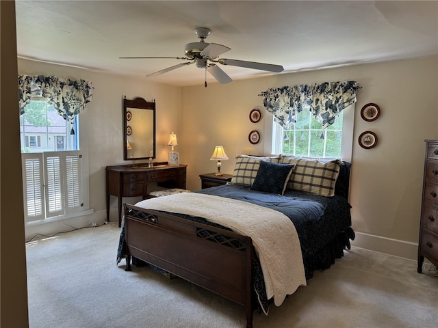 carpeted bedroom with ceiling fan and multiple windows