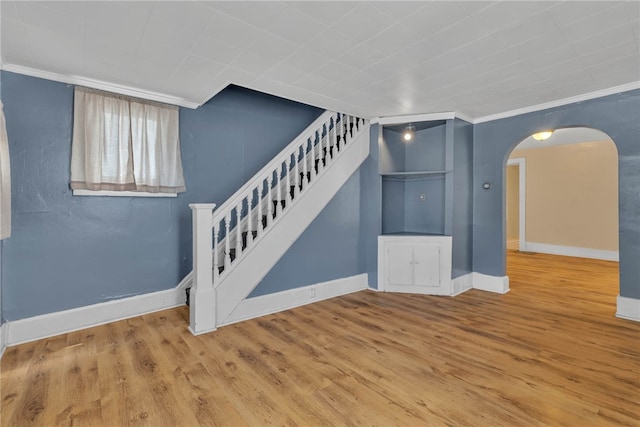 interior space with ornamental molding and hardwood / wood-style flooring