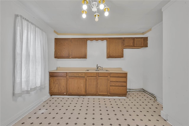 kitchen featuring crown molding, sink, and a notable chandelier