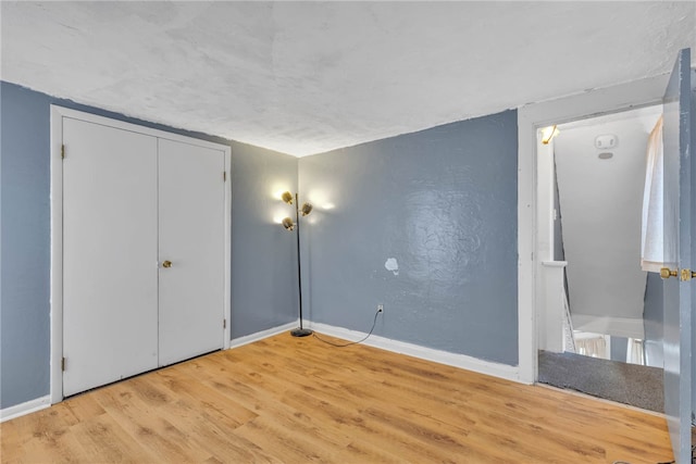 unfurnished bedroom featuring a closet and hardwood / wood-style flooring