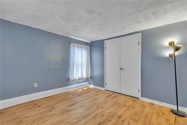 unfurnished bedroom featuring a closet and hardwood / wood-style floors