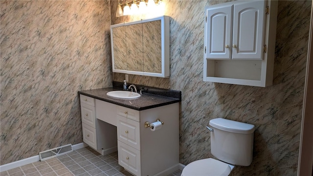 bathroom with tile patterned flooring, toilet, and vanity