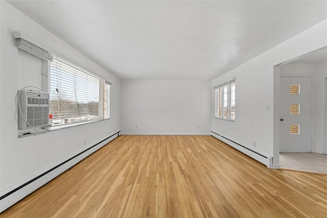 empty room featuring baseboard heating and light hardwood / wood-style flooring