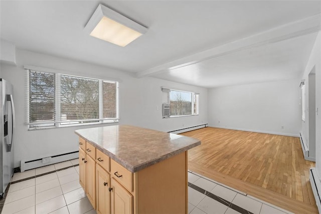 kitchen with a kitchen island, light tile patterned floors, light brown cabinets, and a baseboard radiator