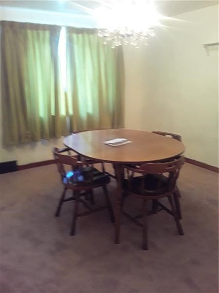 carpeted dining area with a notable chandelier