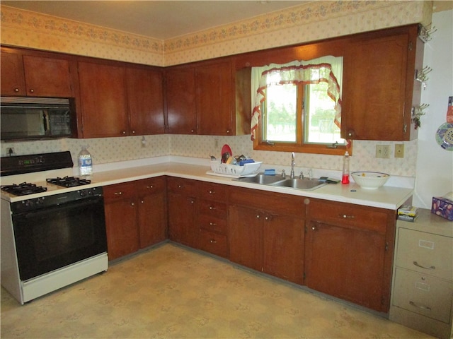 kitchen with white gas range and sink