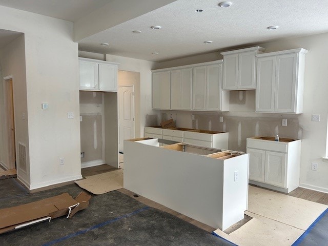 kitchen featuring white cabinetry, a kitchen island, and sink