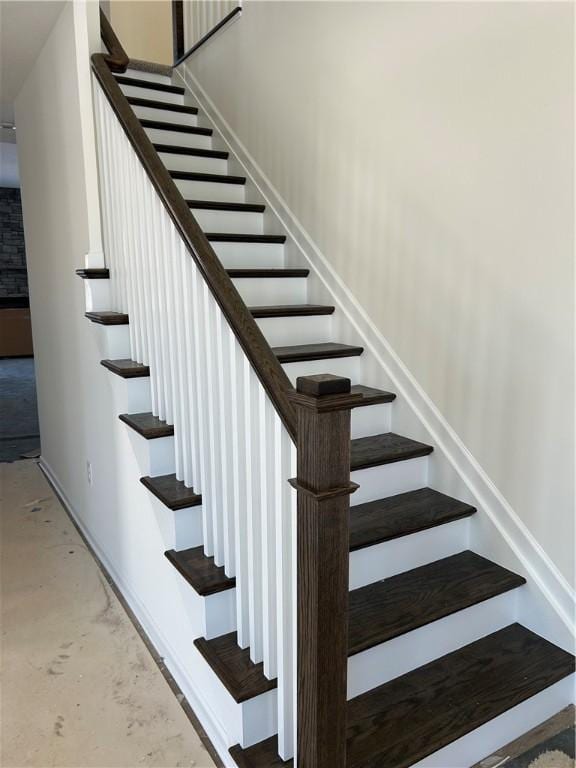 stairs featuring concrete flooring