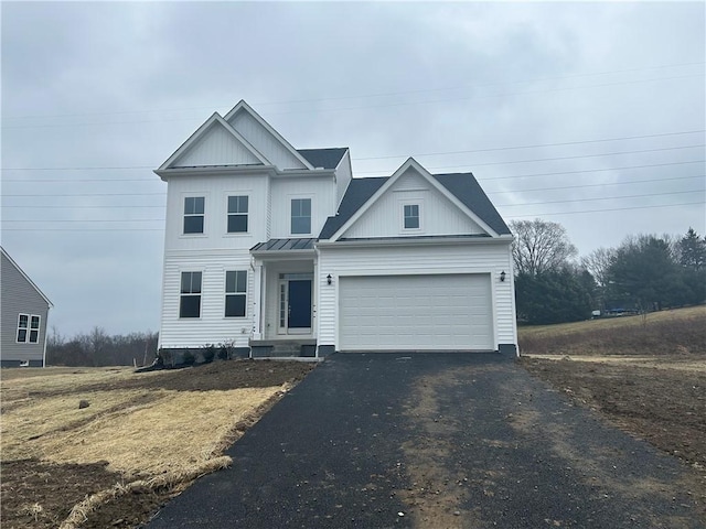 traditional-style home featuring an attached garage, board and batten siding, a standing seam roof, metal roof, and driveway