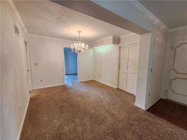 unfurnished room with ornamental molding, carpet, a textured ceiling, and a chandelier